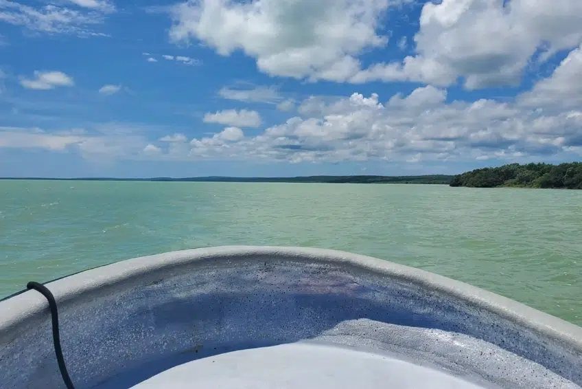 Boat bow view cruising across wide green waters of Laguna de Oviedo