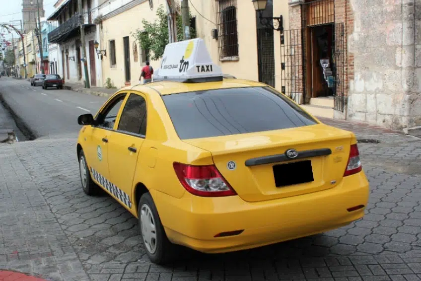 Yellow taxi parked on cobblestone street in Cabo Rojo, Dominican Republic