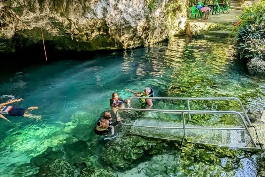 Swimmers in turquoise cave pool at Arroyo Salado