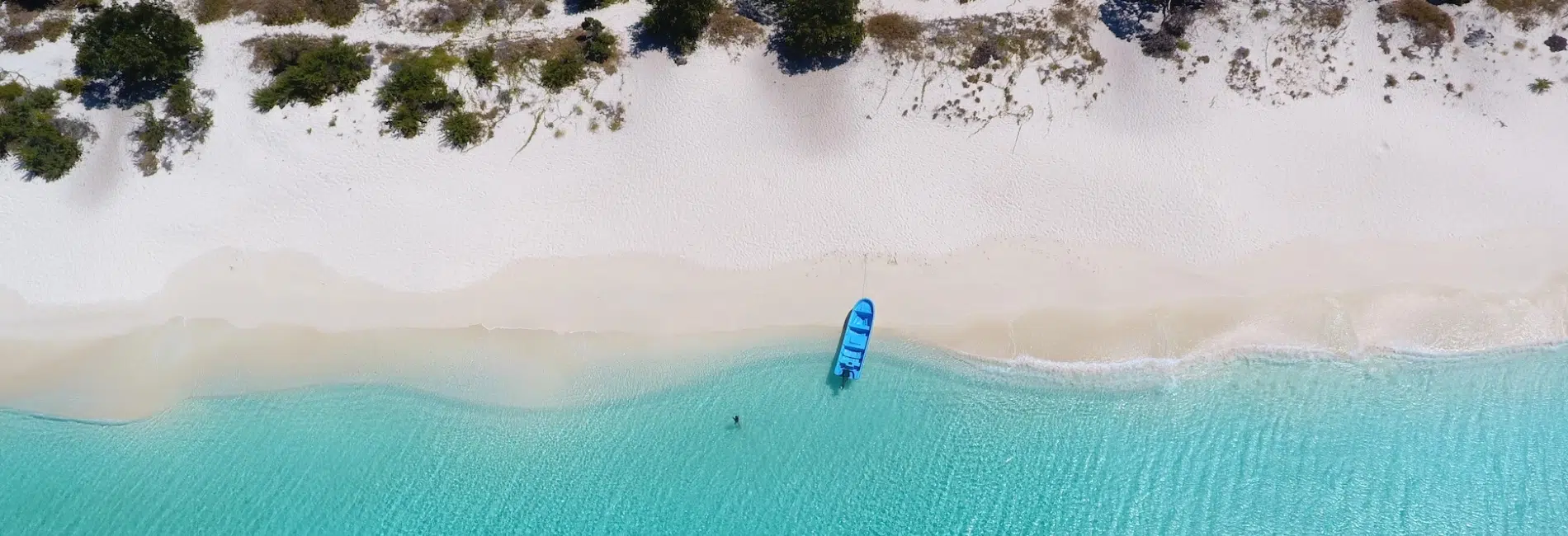 Boat anchored at pristine white sands of Bahia de las Aguilas