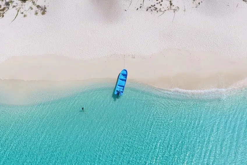 Boat beached on white sand shoreline of Bahia de las Aguilas