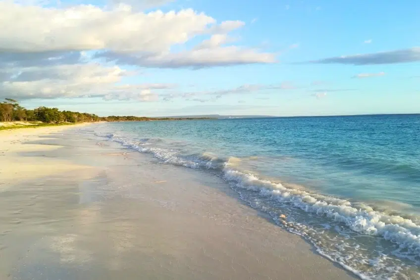 White sands of Bahia de las Aguilas with gentle waves at golden hour