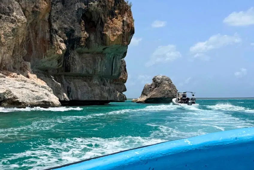 Boat tour passing dramatic limestone sea cliffs and rock formation