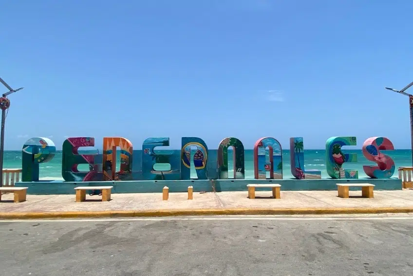 Colorful painted Pedernales sign overlooking turquoise Caribbean sea