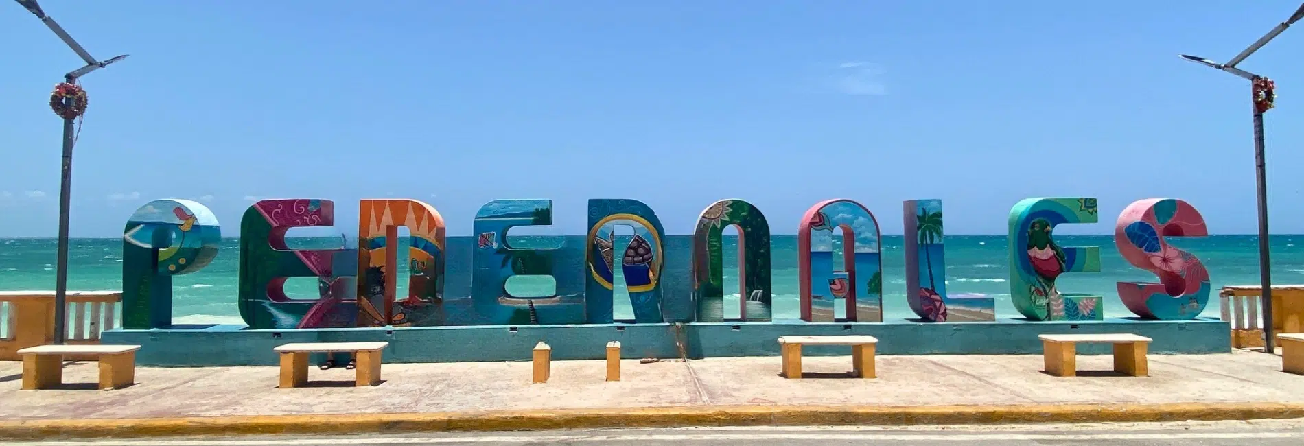 Mural painted Pedernales sign overlooking turquoise Caribbean sea