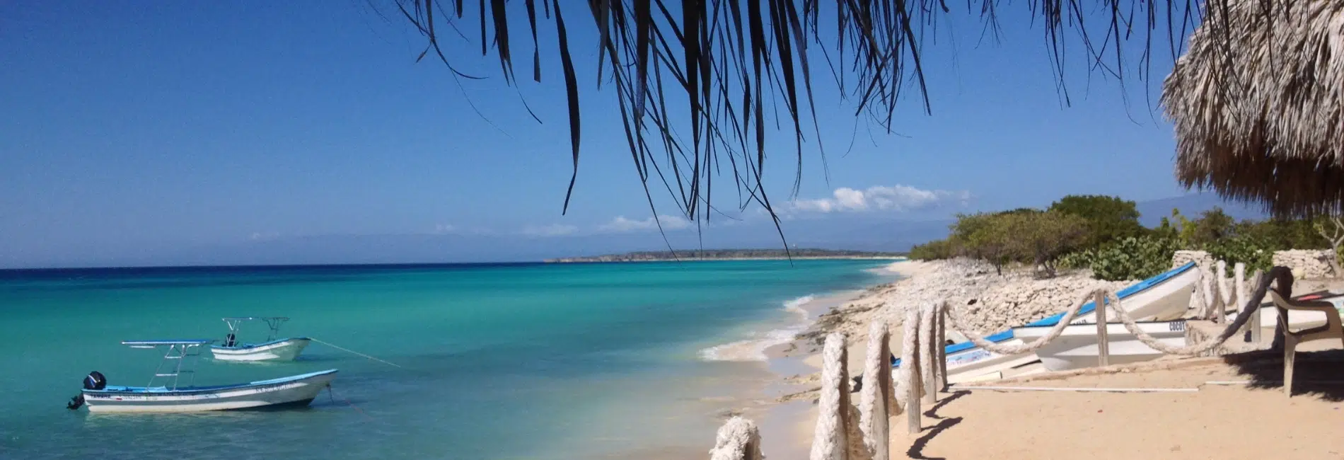 Thatched palapa with boat anchored offshore at Bahia de las Aguilas