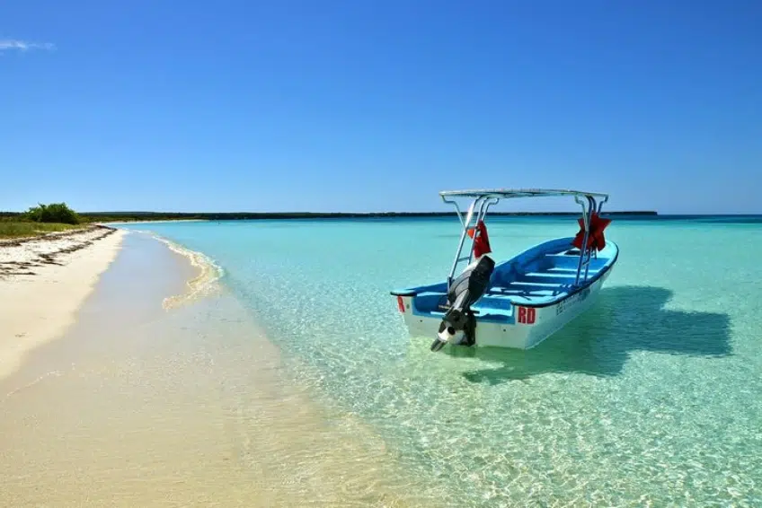 Boat resting in crystal clear shallow water of Bahia de las Aguilas