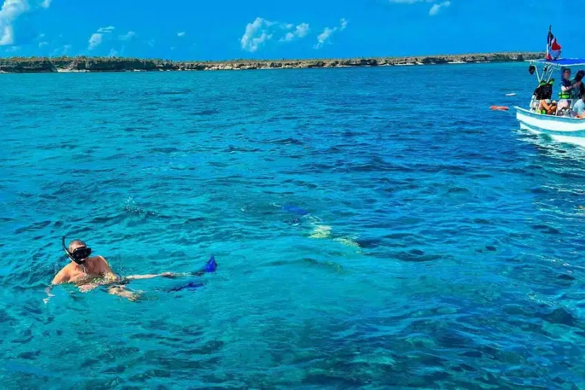 Snorkeler exploring turquoise waters of Bahia de las Aguilas near tour boat