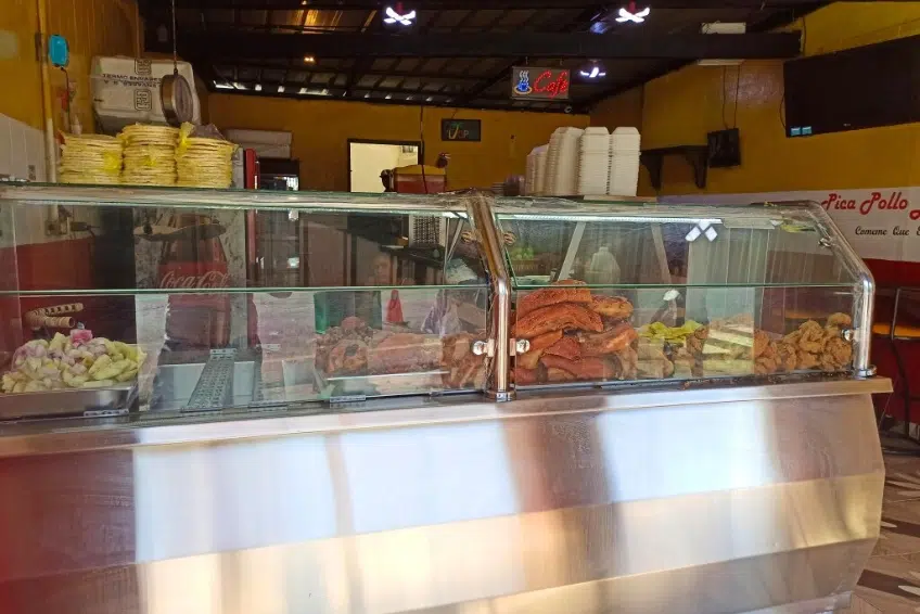 Local comedor food counter displaying meats and fried foods