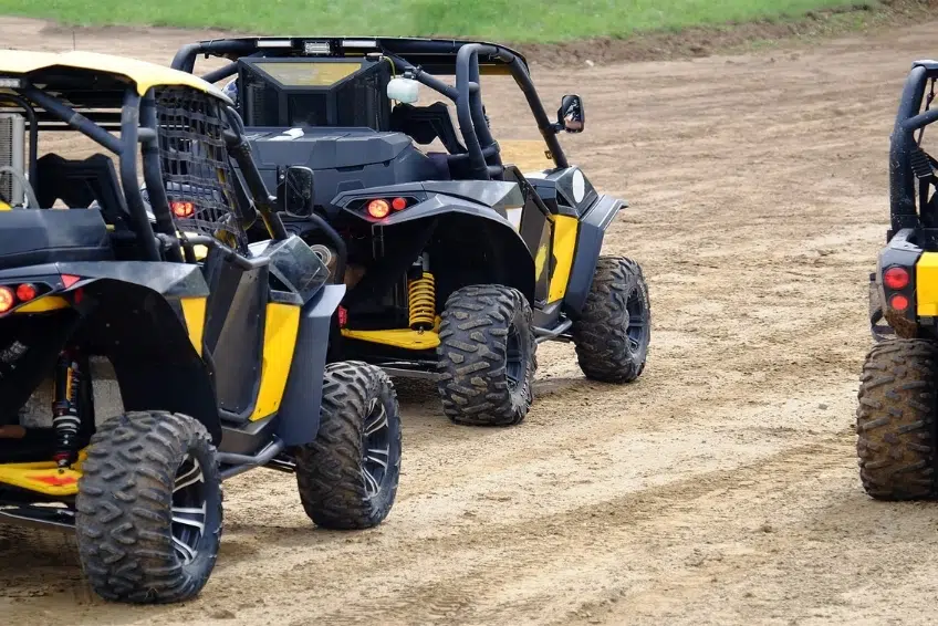 Yellow and black off-road buggies driving on sandy dirt trail - ATV and Buggy Tours