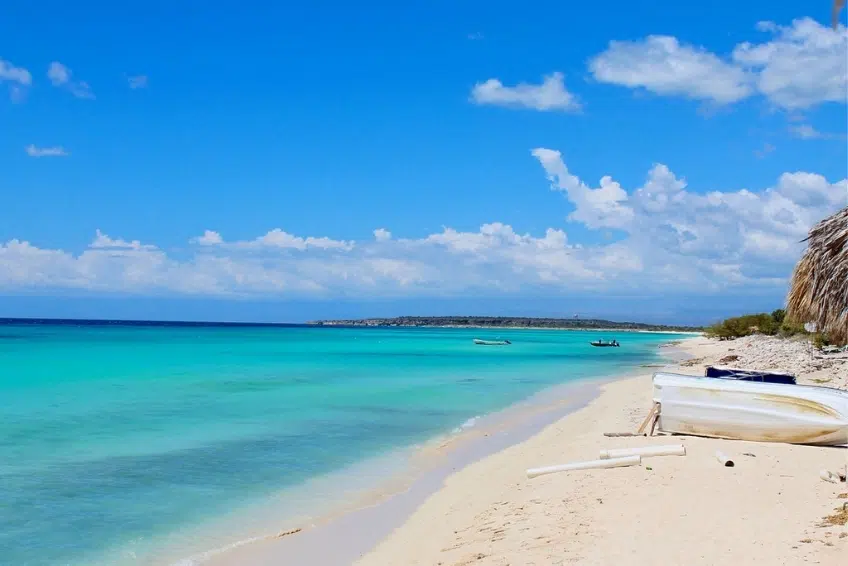 Overturned boat on the empty white sand of Bahia de las Aguilas