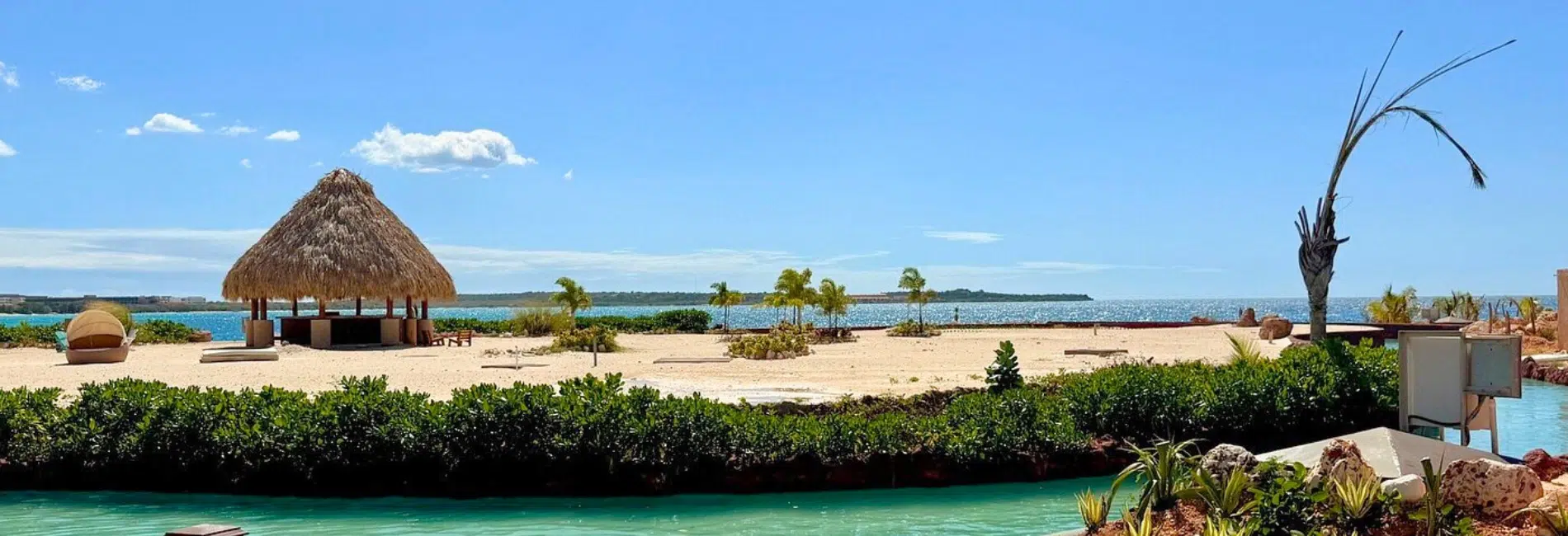 Lazy river winding past lounge chairs and thatched gazebos at Cabo Rojo Cruise Port