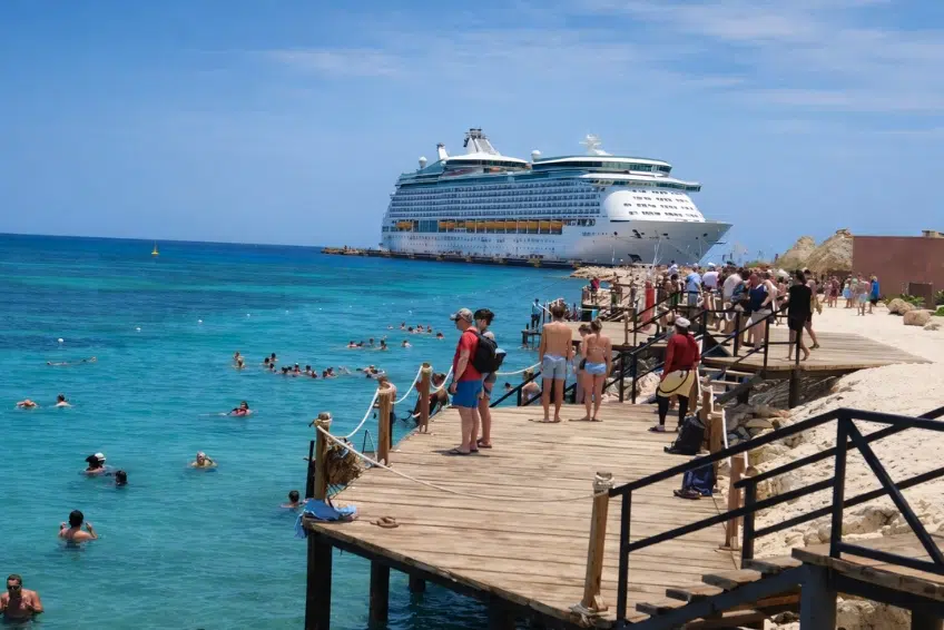 Cruise ship docked at Cabo Rojo with swimmers and wooden pier