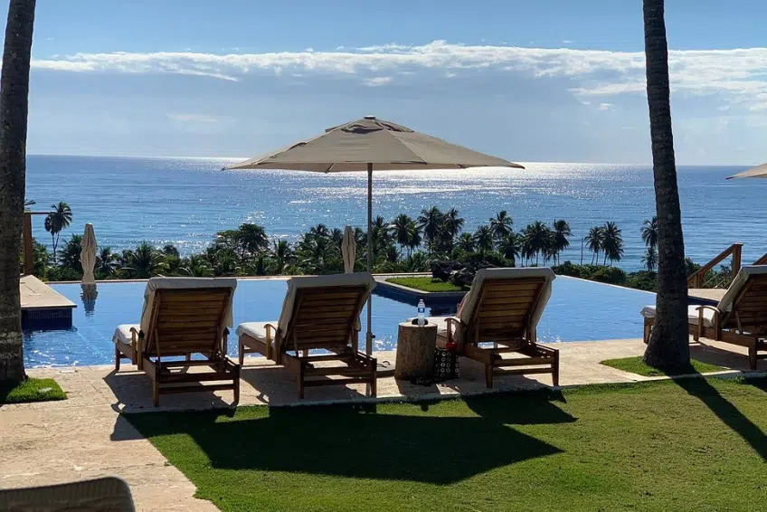 Infinity pool with lounge chairs overlooking ocean at Casa Bonita