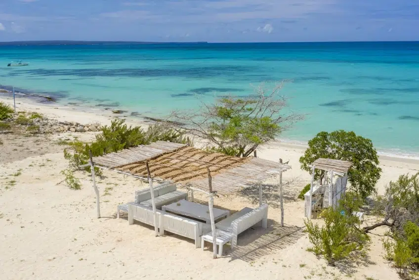 Beachfront lounge cabana with rustic wood canopy and ocean view at Eco del Mar Beach Club