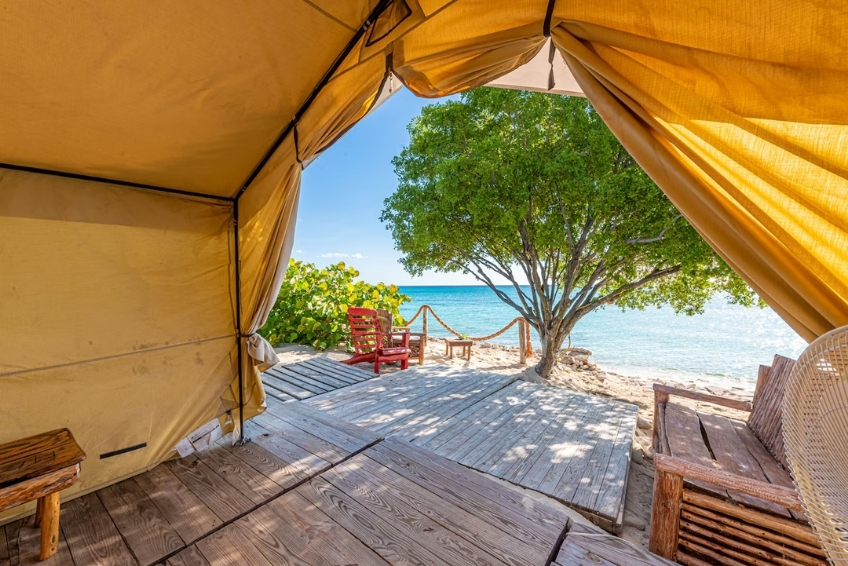 View from inside glamping tent onto wooden deck and ocean at Glamping EcoLodge Cueva de las Aguilas