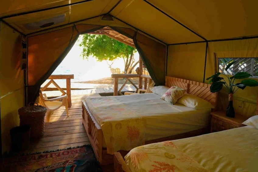 Glamping tent interior with two beds and open ocean view at Glamping EcoLodge Cueva de las Aguilas