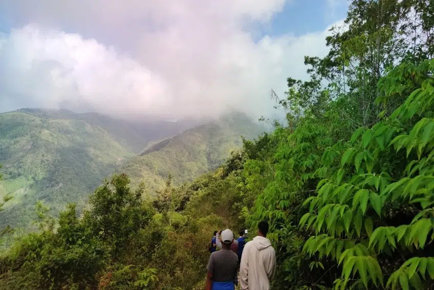 Hikers descending misty mountain ridge in Sierra de Bahoruco