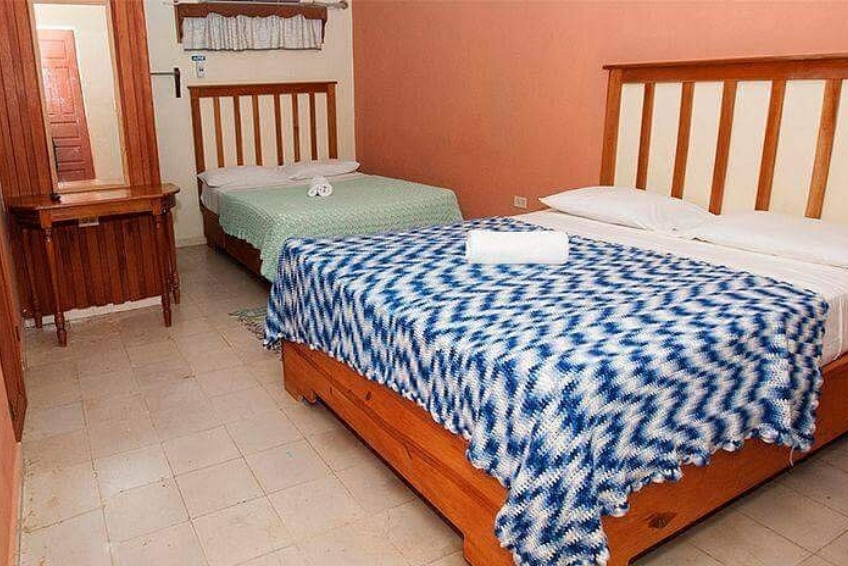 Room at Hostal Dona Chava with two wooden beds and blue patterned bedspreads