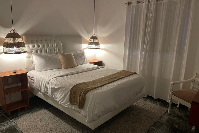 Room at Hotel Casa Bajari with tufted headboard and woven pendant lights