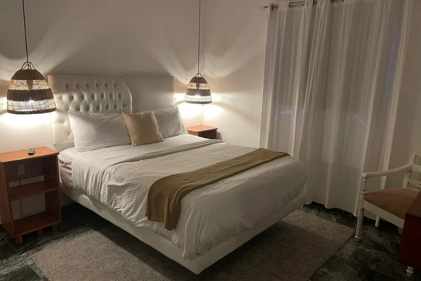 Room at Hotel Casa Bajari with tufted headboard and woven pendant lights