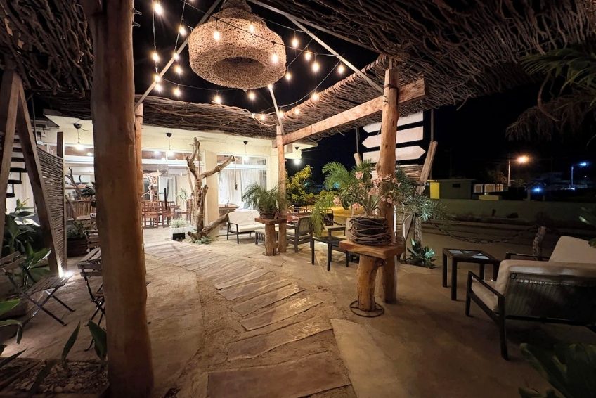 Rustic outdoor lounge with string lights at night at Hotel Casa Bajari