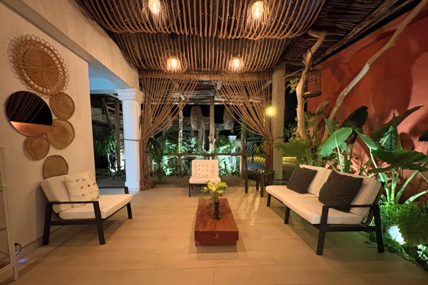 Elegant open-air lounge with bamboo ceiling and white sofas at night at Hotel Casa Bajari