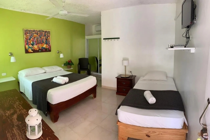 Room at Hotel Pedernales Italia with green accent wall and two beds