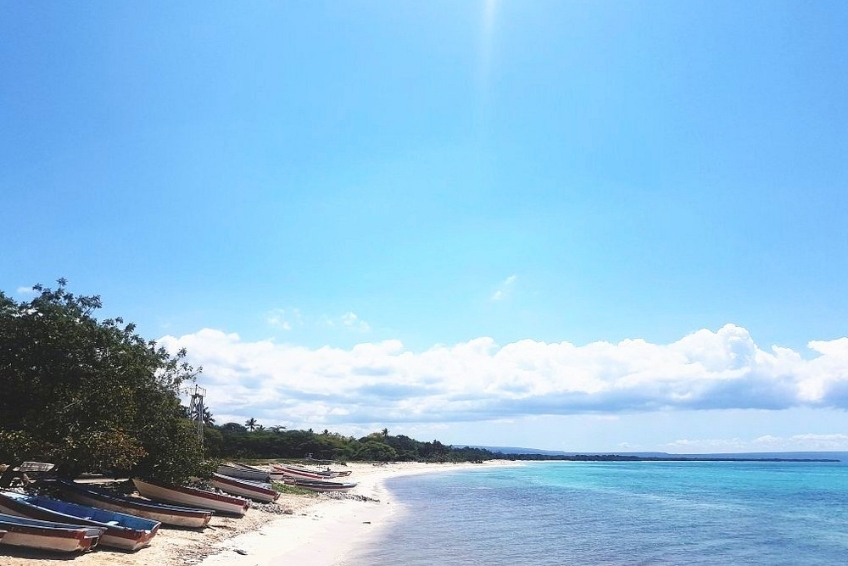 Fishing boats lined up along calm turquoise shoreline of Cabo Rojo at Hotel Pedernales Italia