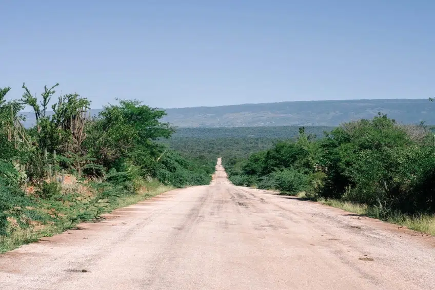 Hoyo de Pelempito road flanked by tropical trees and mountains