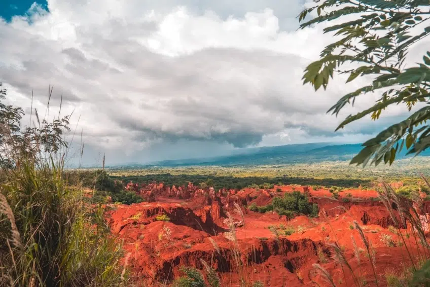 Red rock canyon landscape of Hoyo de Pelempito with lush green valley beyond