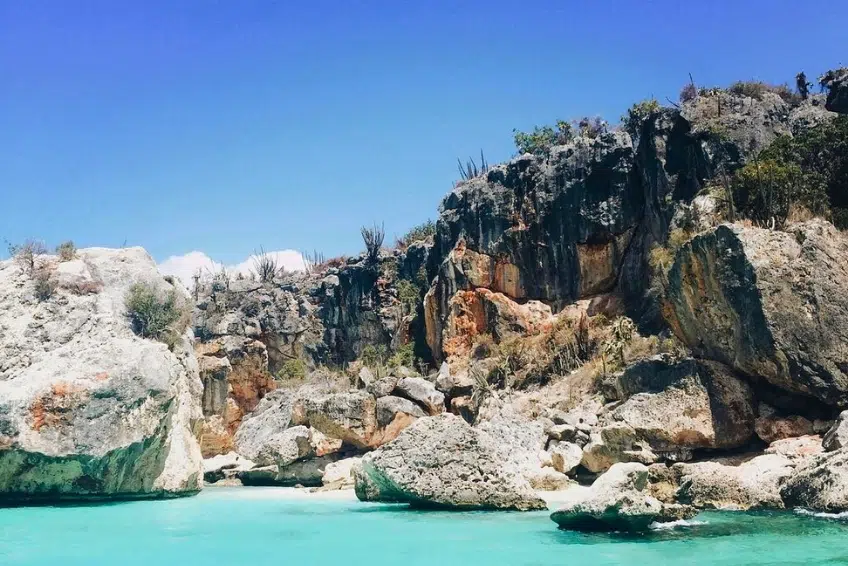 Rugged limestone cliffs meeting clear turquoise water in National Park