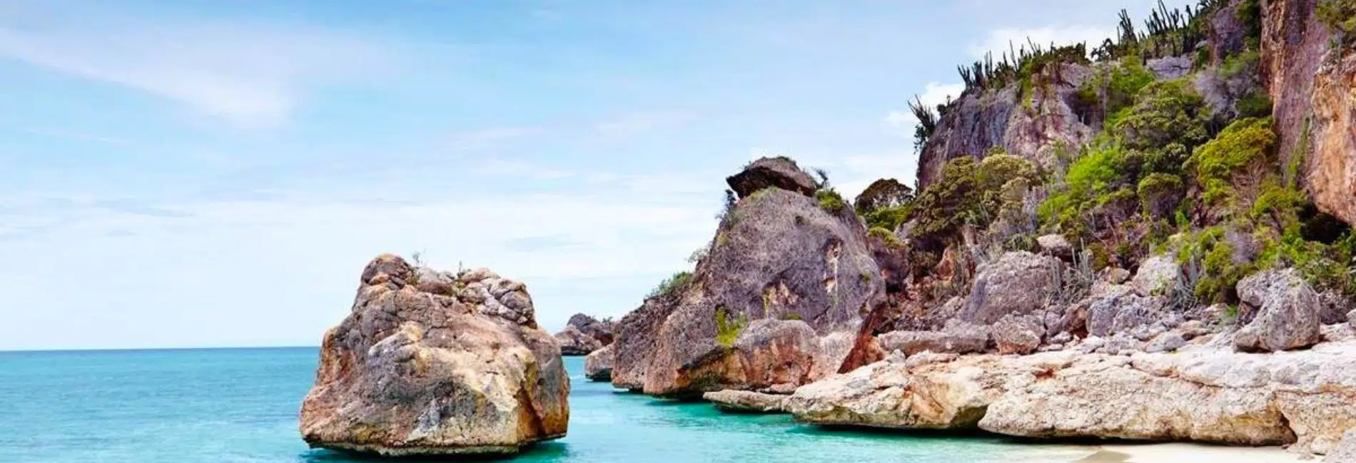 Turquoise cove beside Jaragua National Park rocky cliffs