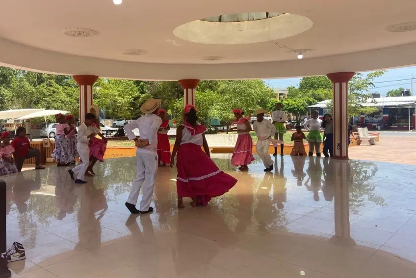 Traditional folk dancers performing in colorful costumes at Pedernales town pavilion