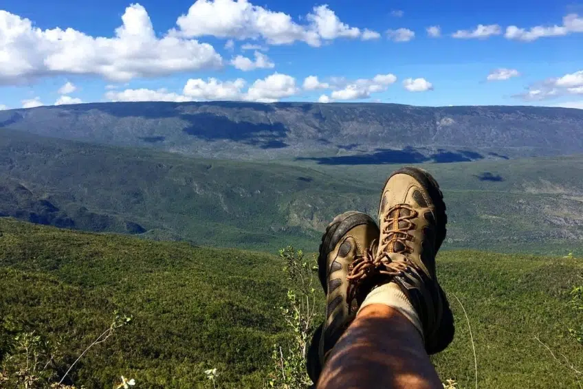 Hiker's boots propped up overlooking vast mountain valley at the Hoyo de Pelempito Viewpoint