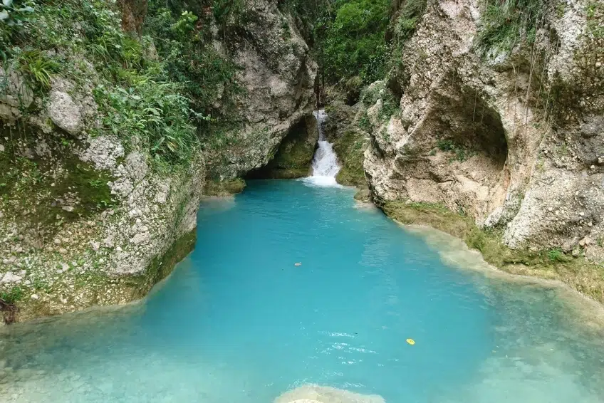 Brilliant blue waterfall cascading into turquoise canyon natural pool