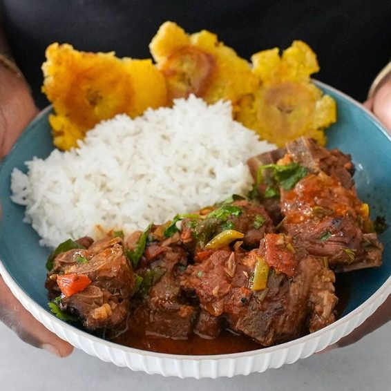 Where To Stay - Prepare For Dinner A bowl of chivo guisado stewed meat rice and tostones