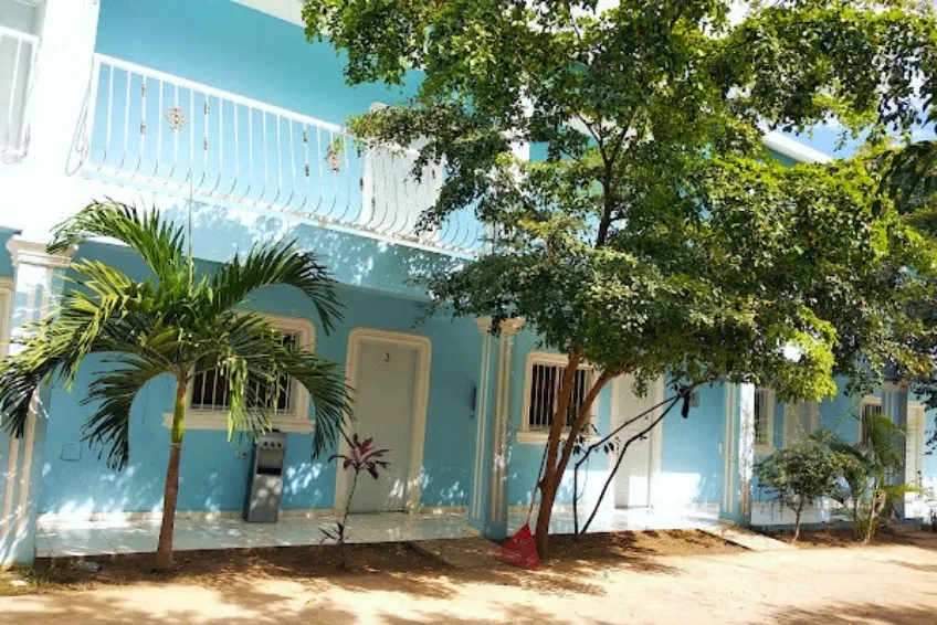 Light blue colonial-style building with palm trees in Pedernales, Cabo Rojo, DR