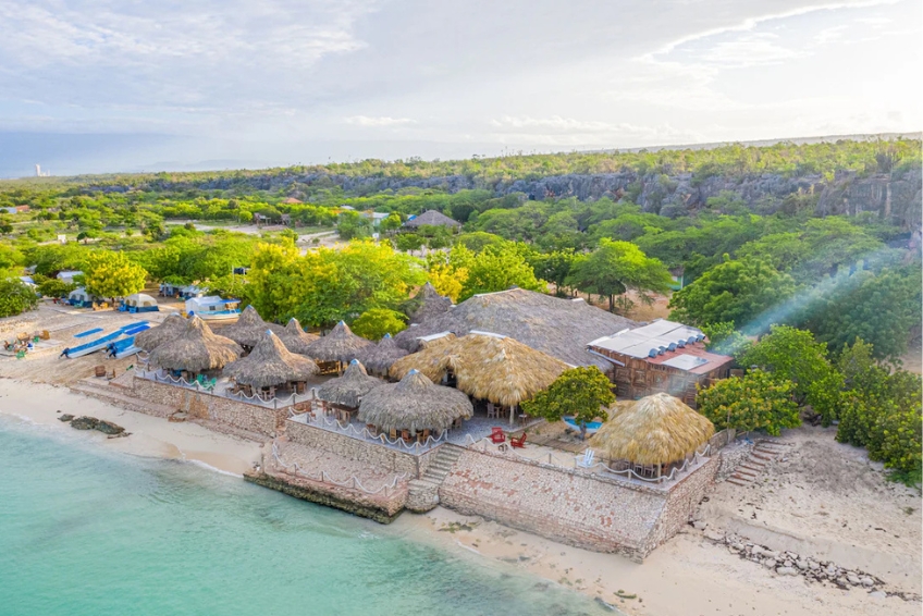View of thatched beach lodge Glamping EcoLodge Cueva de las Aguilas in Cabo Rojo, DR