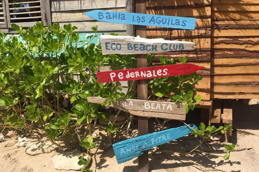 Colorful wooden directional sign in Cabo Rojo pointing to Bahia Las Aguilas and nearby destinations