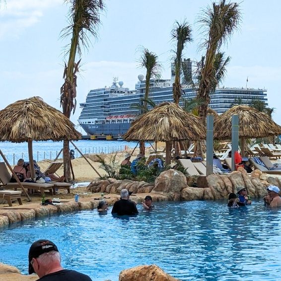 Resort pool with palapa umbrellas and cruise ship view at Port Cabo Rojo