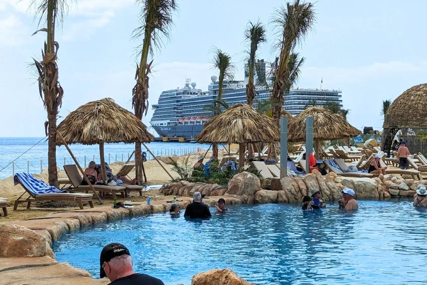 Baby Beach Club guests relaxing in pool with Port Cabo Rojo in the background