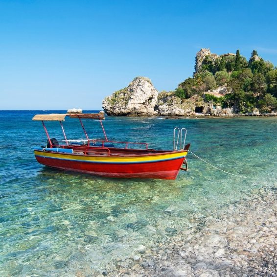 Colorful boat anchored in turquoise Caribbean beach water of Bahia de las Aguilas