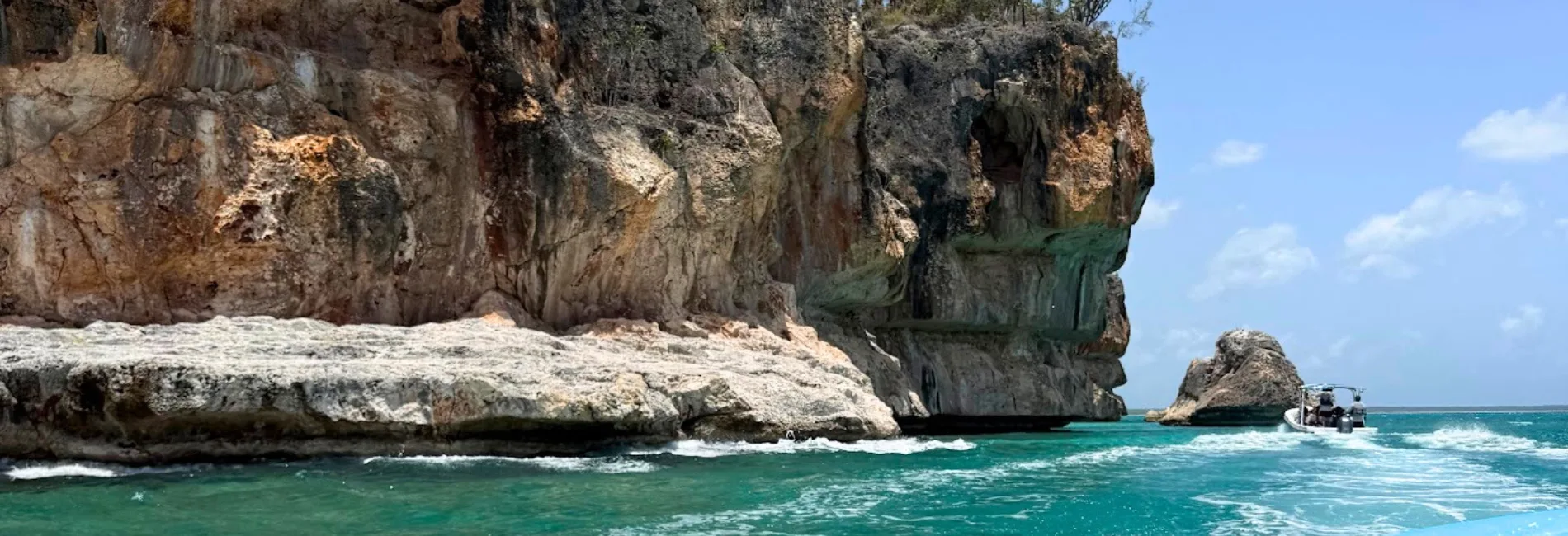 Boat tour passing dramatic cliffs at Jaragua National Park