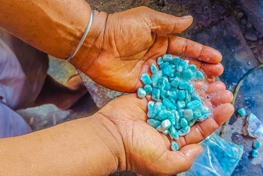 Hands holding freshly mined raw Larimar stones