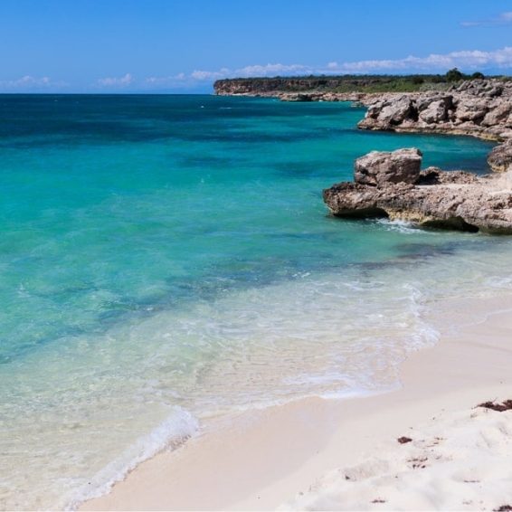 Turquoise water lapping rocky white sand at Baby Beach in Cabo Rojo