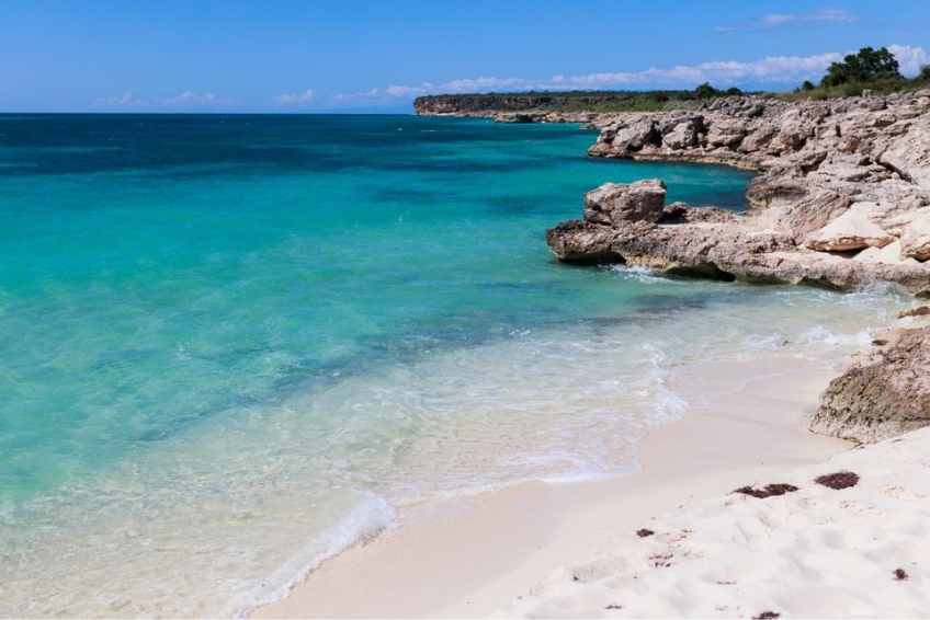 Turquoise water lapping rocky white sand at Baby Beach in Cabo Rojo