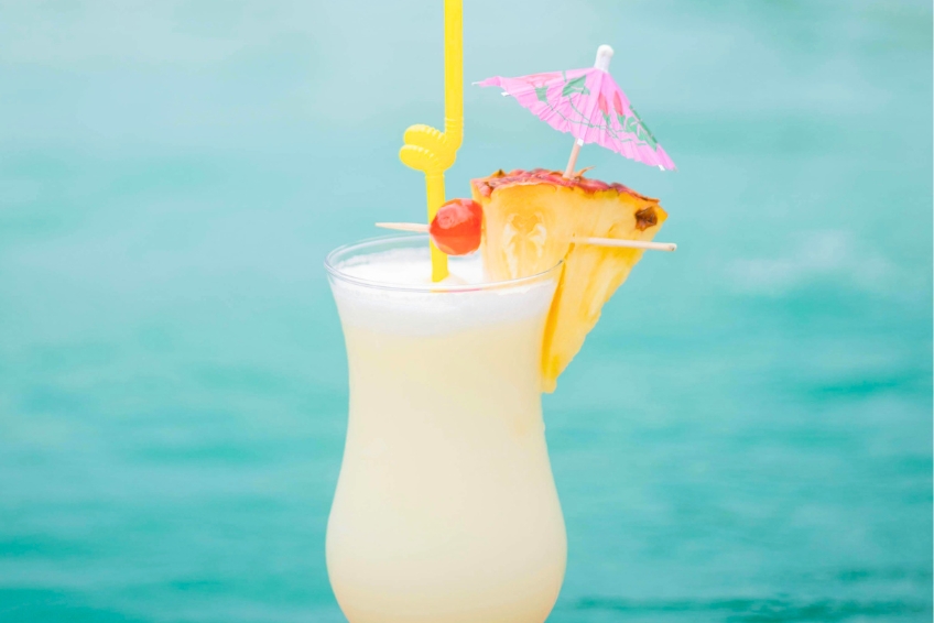 Tropical cocktail by the pool with pineapple and umbrella in Cabo Rojo