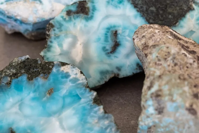 Close-up of blue geode rocks with white crystalline centers and rough outer crusts in brown and gray tones.