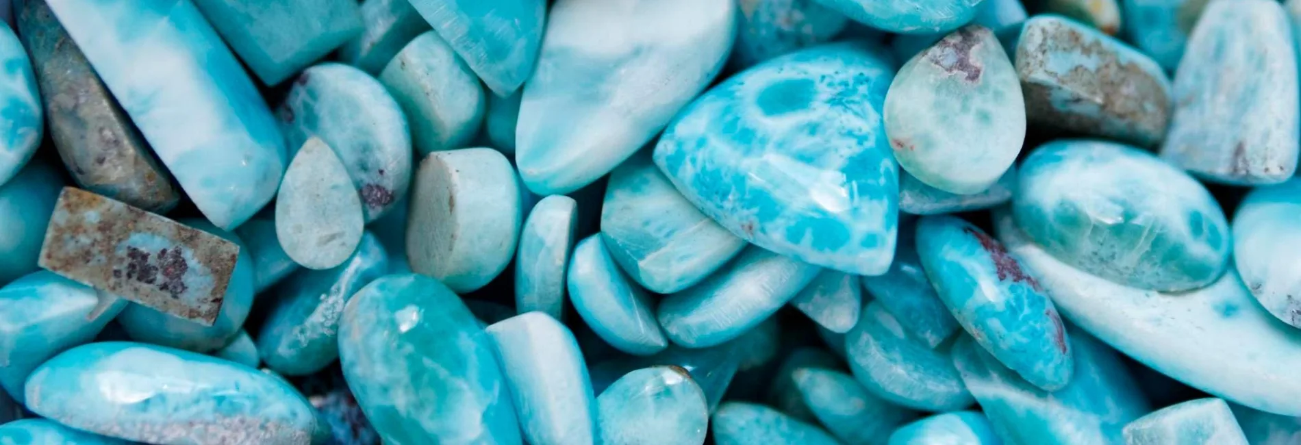 Smooth turquoise blue stones piled together in a close-up view